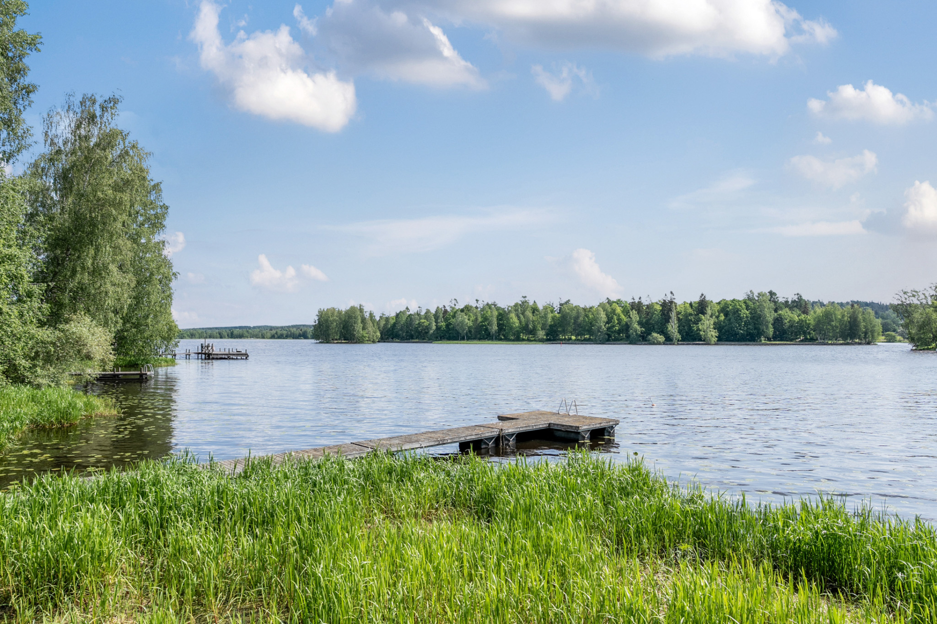 Järvimaisema laiturilta kirkkaana kesäpäivänä – suomalainen juhannusnäkymä